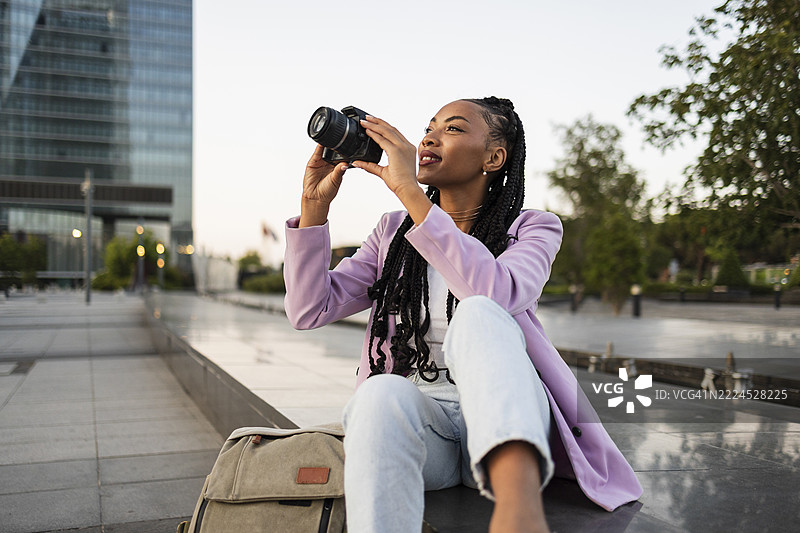 年轻摄影师用相机捕捉城市风光瞬间图片素材