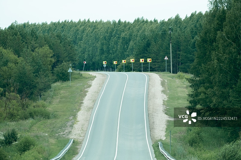 空旷的高速公路，两旁是森林。图片素材