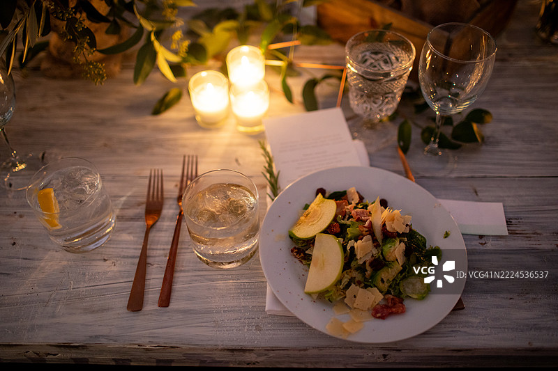 烛光下的精致沙拉餐具摆设图片素材