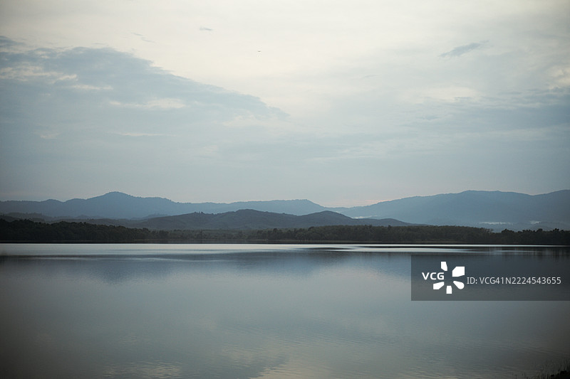 泰国宋卡的宁静泻湖前景中，层层叠叠的山脉全景。图片素材