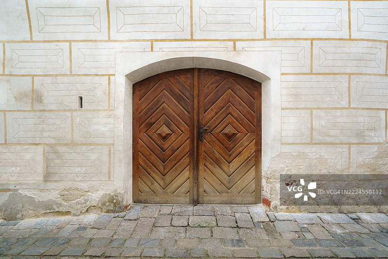 历史外立面上的风化人字形木门图片素材