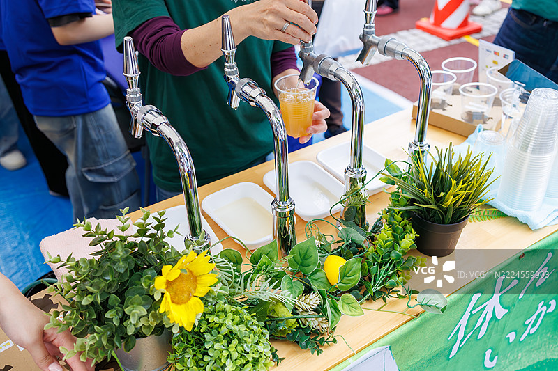 一名服务员在倒啤酒。对小岛上的当地啤酒进行比较。图片素材