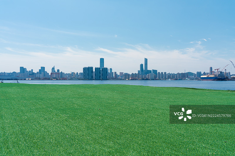 草地与海洋和城市天际线图片素材