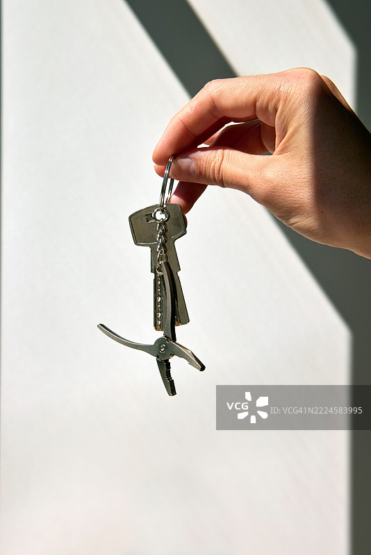 手握钥匙和钥匙圈上的多功能工具图片素材