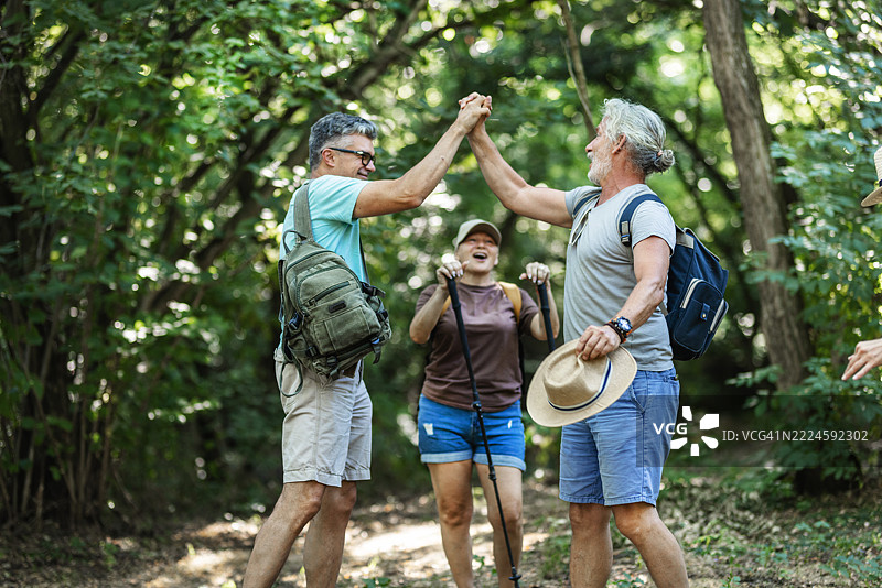 活跃的老年人和朋友们在自然徒步旅行中聊天图片素材