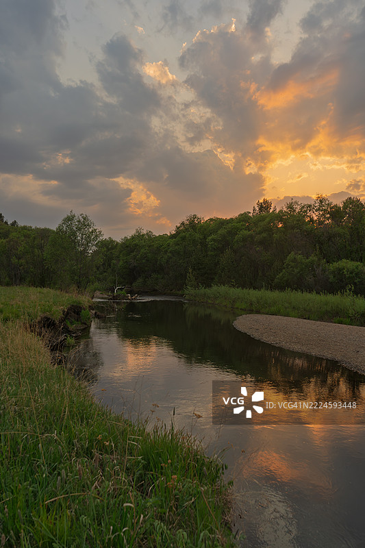 河边森林中的日落。图片素材
