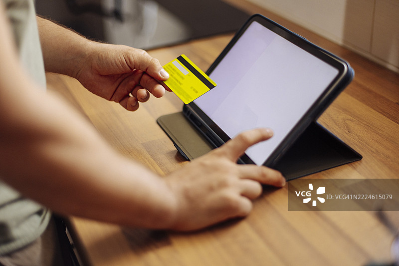 男子使用平板电脑进行在线支付图片素材