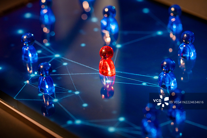 红色棋子在平板电脑上引导蓝色棋子形成网络连接的可视化图像图片素材