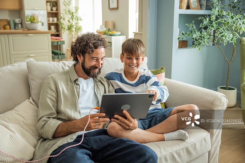 父亲和儿子在家使用平板电脑图片素材