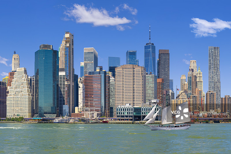 纽约市天际线与帆船，曼哈顿金融区摩天大楼，世贸中心，东河和清晨的蓝天。图片素材