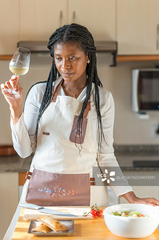 女性厨师在现代厨房中闻白葡萄酒图片素材