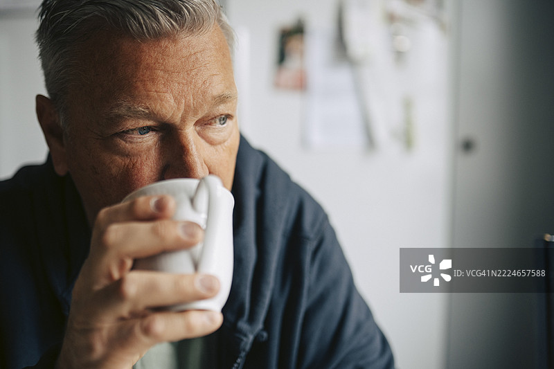 在家中喝咖啡的沉思老者图片素材