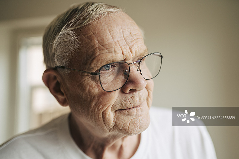 老年男子戴着眼镜，侧目而视的特写镜头图片素材