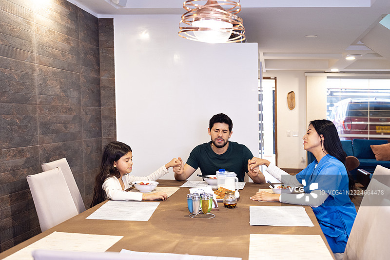 拉丁家庭在早餐前手牵手祈祷图片素材