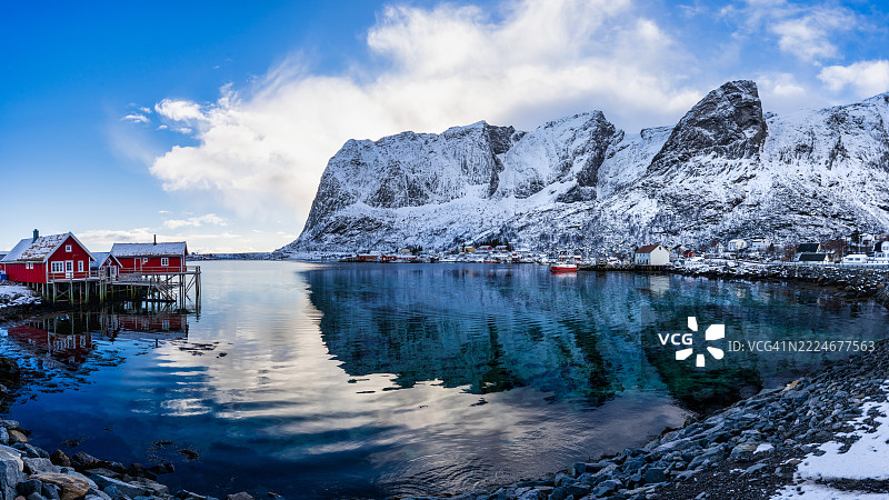 挪威洛福滕群岛诺尔兰的雷纳，冬季峡湾水边的传统红色木制渔民小屋（Rorbuer）图片素材