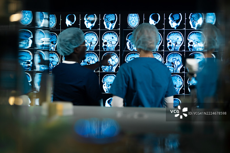 一男一女在实验室讨论MRI脑部扫描的结果。图片素材