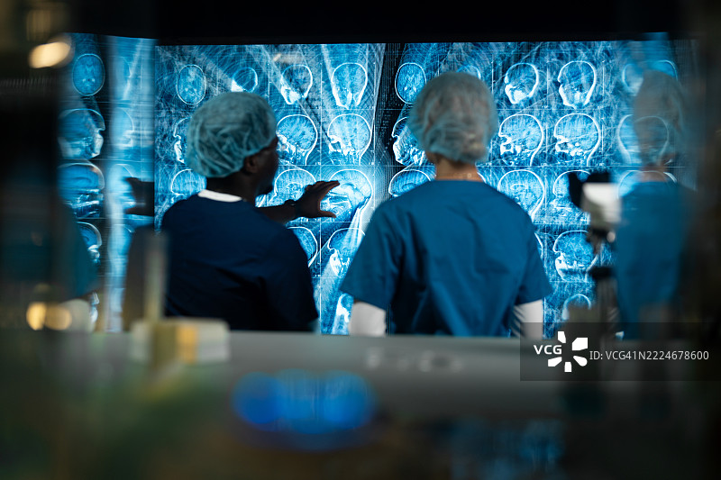 一男一女在实验室讨论MRI脑部扫描的结果。图片素材
