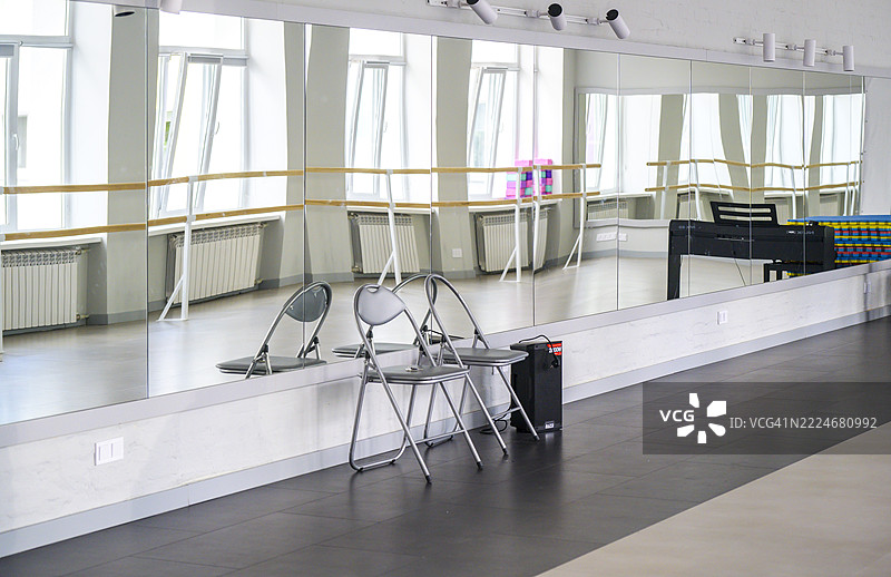 空荡荡的舞蹈教室，巨大的镜子映照着舞杠和钢琴图片素材