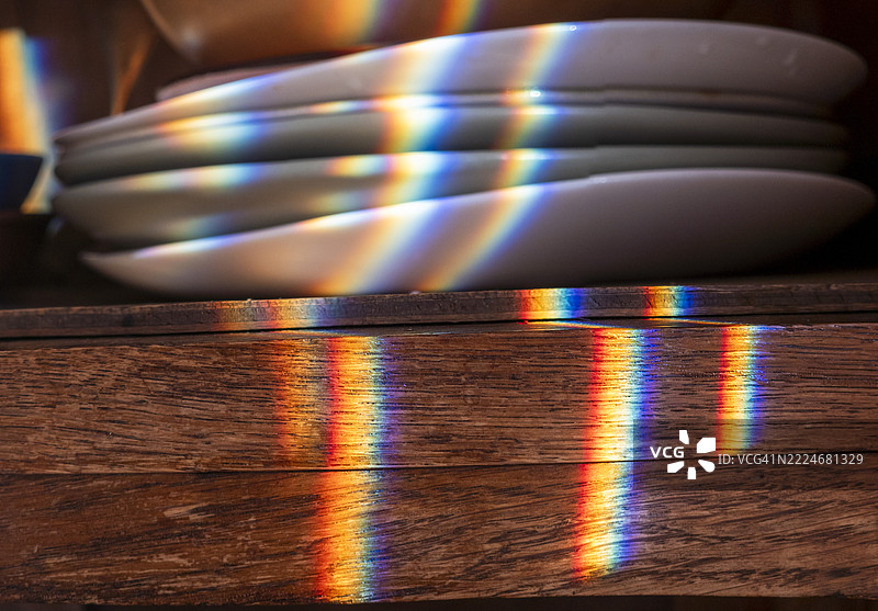 彩虹投射在盘子和木制家具上图片素材