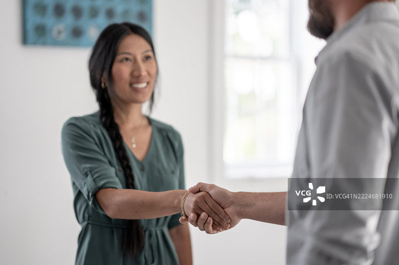 明亮办公室环境中男女之间的商务握手图片素材