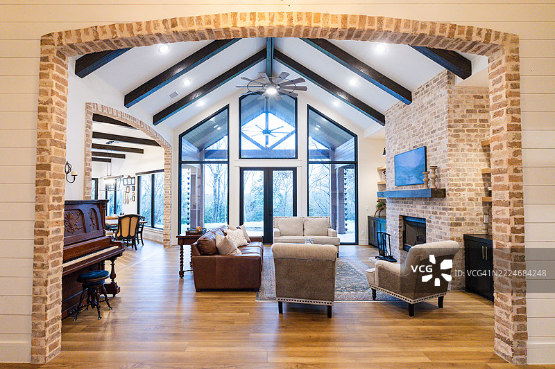 现代农舍风格的客厅，配有砖砌壁炉和大窗户图片素材