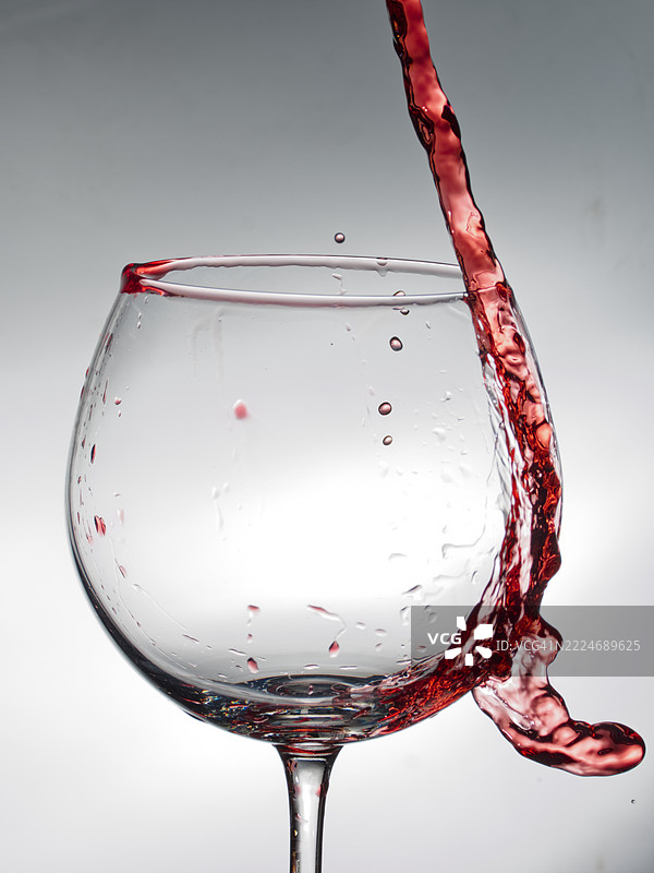 红酒在白色背景上飞溅的特写镜头图片素材