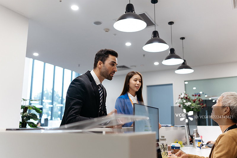 商务人士在办公室与接待员交谈图片素材