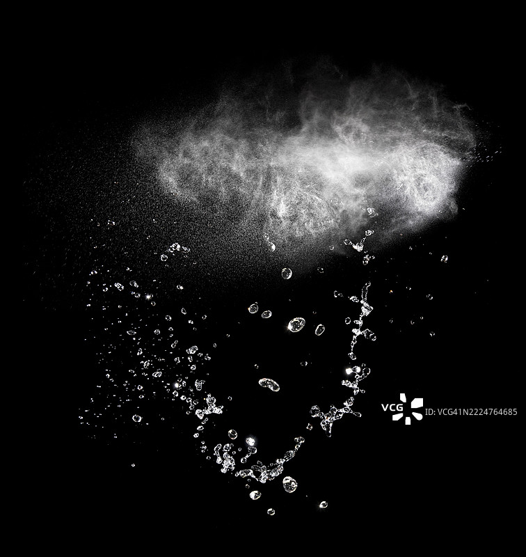 黑色背景上的水雾和水花飞溅，伴随移动的水滴。图片素材