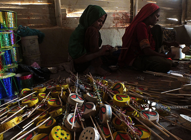 一个巴基斯坦印度教家庭忙于制作玩具和其他游戏材料。图片素材
