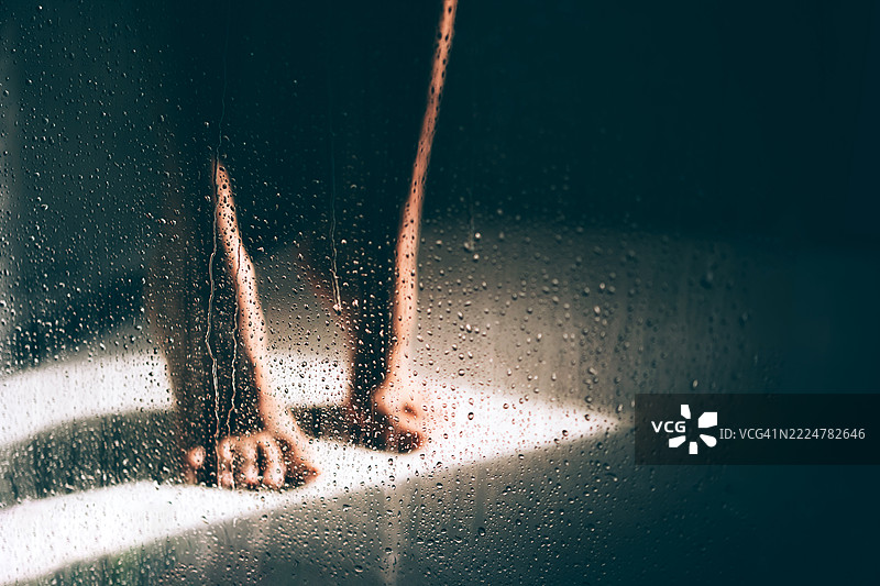 阳光照射下的淋浴间，女人的脚周围水花四溅图片素材