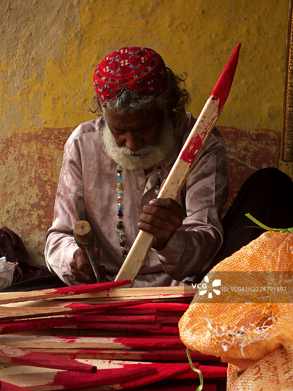 一个巴基斯坦印度教家庭忙于制作玩具和其他游戏材料。图片素材