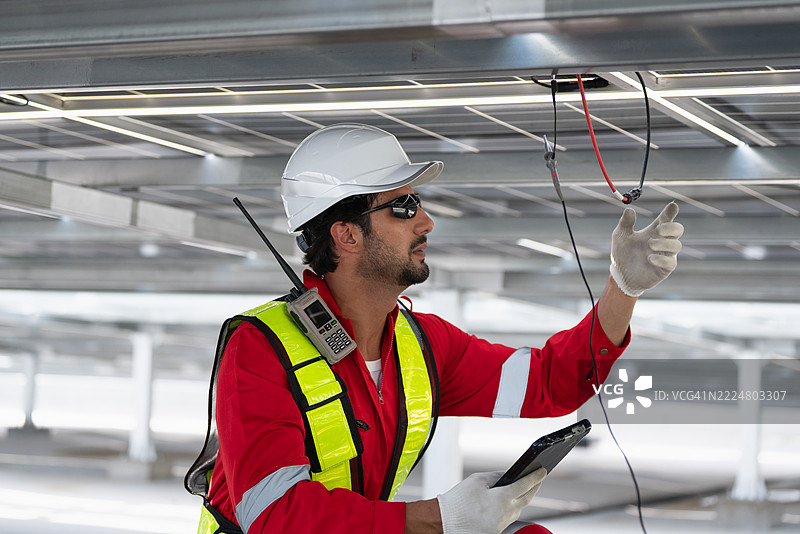 工程师团队在工厂屋顶上检查、维护和服务大规模太阳能电池板安装，以实现可持续的可再生能源生产和工业效率。图片素材