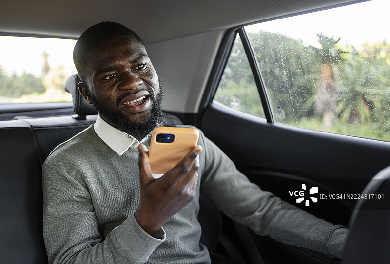 非洲商人在城市中开车时通过免提电话交谈图片素材