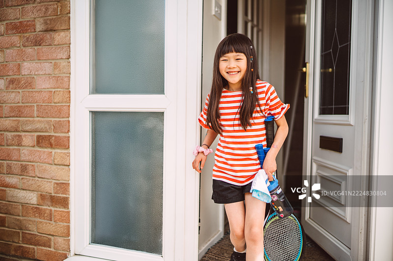 快乐的小女孩在夏天的日子里前往羽毛球训练。图片素材