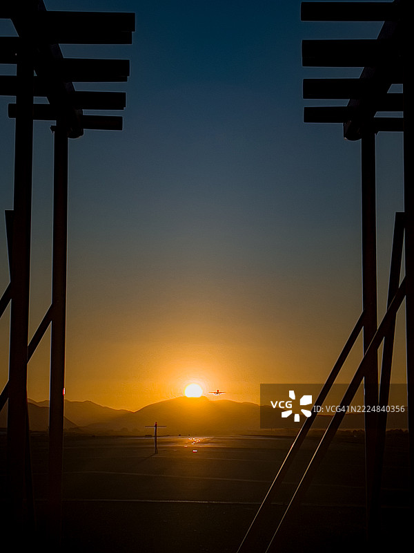 飞机在金色日落的背景下起飞，阳光洒落。图片素材