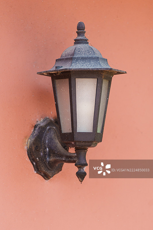 橙色墙壁上的旧灯笼。图片素材