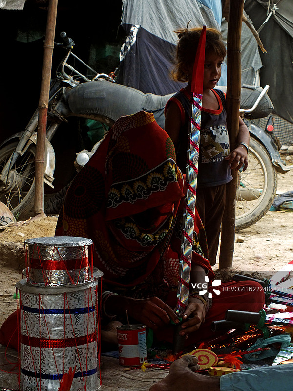 一个巴基斯坦印度教家庭忙于制作玩具和其他游戏材料。图片素材