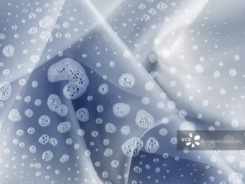 蓝色浴巾上的肥皂泡沫。图片素材