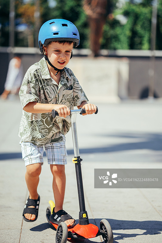 小男孩骑滑板车图片素材