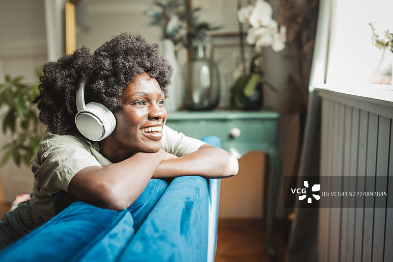 年轻女性在家中戴着耳机享受音乐图片素材