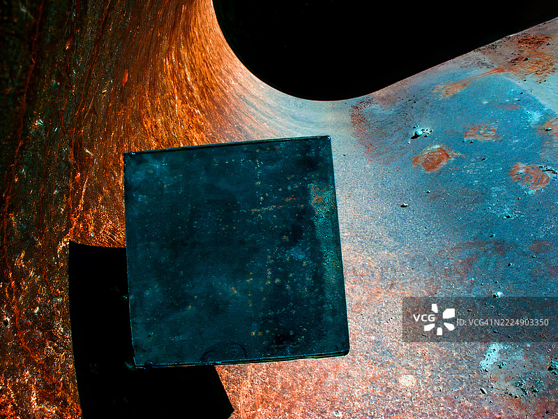 抽象金属立方体及其在生锈表面上的阴影图片素材