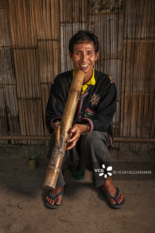 来自泰国北部瑶族的男子抽烟斗图片素材