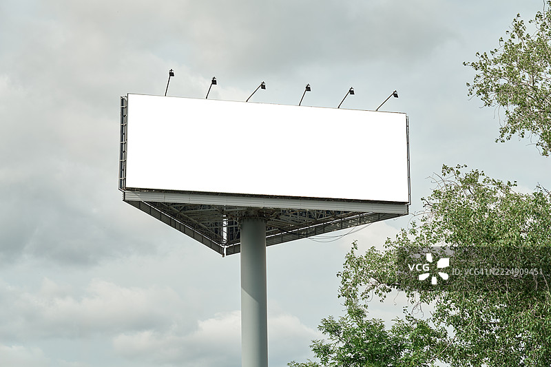 空旷高速公路广告牌模型，带有空白横幅和聚光灯，背景是多云的天空图片素材