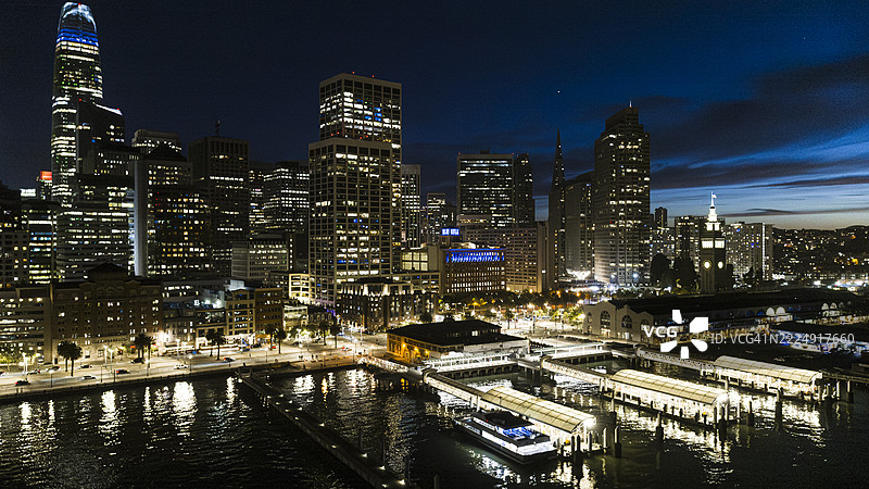 海滨码头在高耸的摩天大楼下闪烁。加利福尼亚州旧金山南海滩区的蓝色时刻景观。图片素材