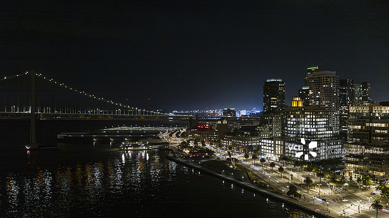 海滨城市的天际线在夜空中闪耀。湾桥连接旧金山与沿着埃姆巴卡德罗海滨的灯火辉煌的商业区。图片素材