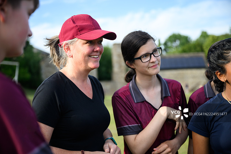 一群女性和女孩在运动场上站在一起聊天图片素材
