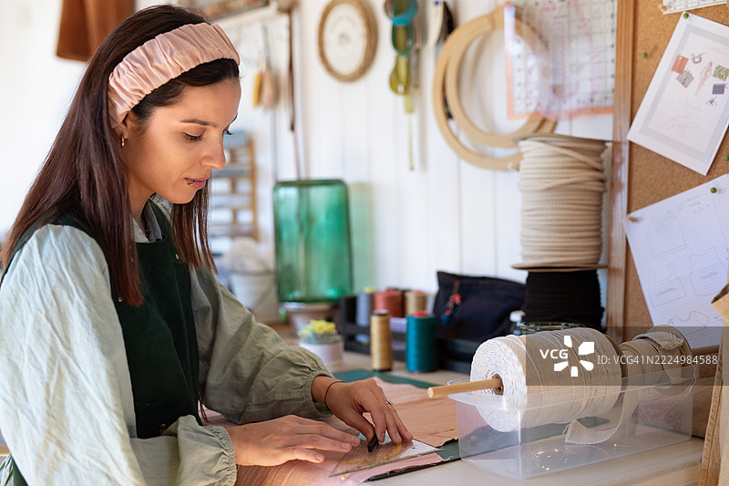 年轻女性纺织企业家在她的创意工作室里图片素材