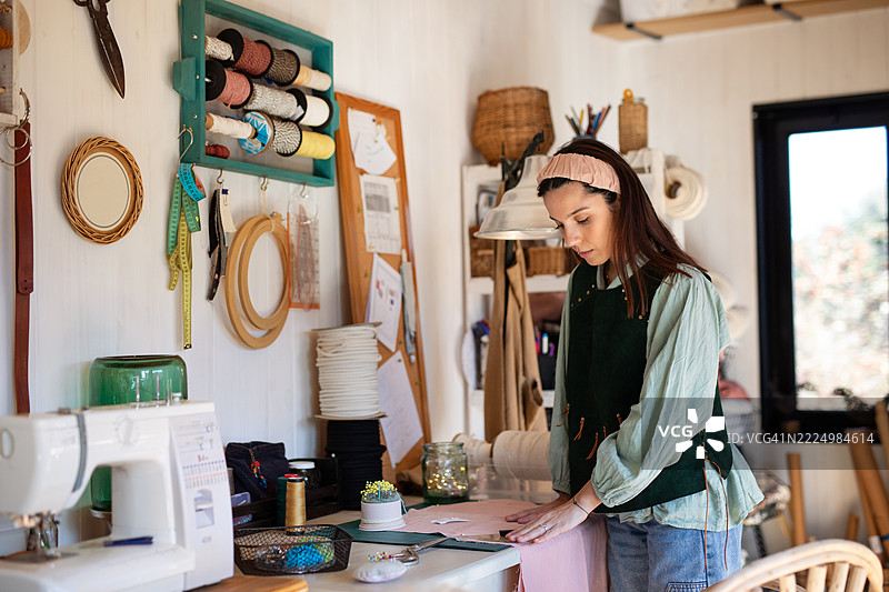 年轻女性纺织企业家在她的创意工作室里图片素材