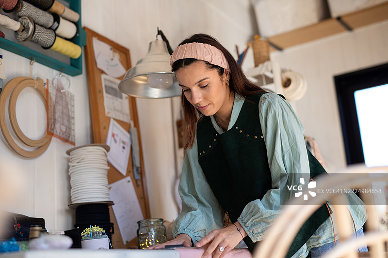 年轻女性纺织企业家在她的创意工作室里图片素材
