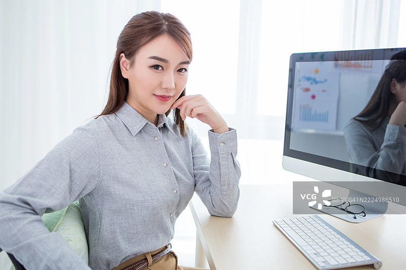 专业的亚洲女性在桌子前工作图片素材